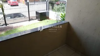 Vista da fachada de uma propriedade com cerca e jardim.