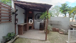 Vista da área externa com parede de tijolos e piso de cerâmica.