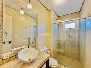 Foto de um banheiro moderno com box de vidro e bancada de mármore.