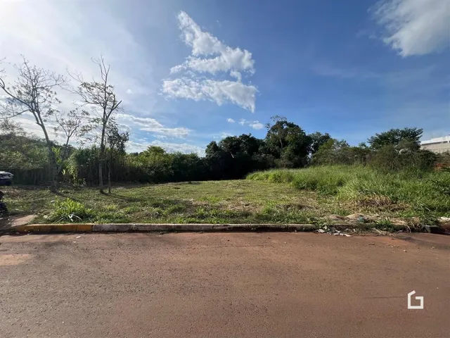 Paisagem de terra e vegetação ao lado de uma estrada.