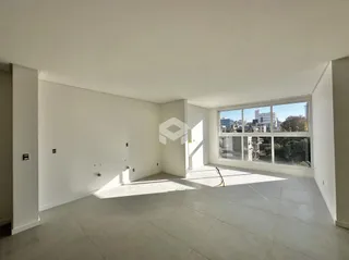 Uma sala ampla com grande janela de vista para a cidade.