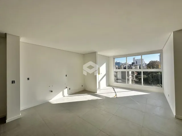 Uma sala ampla com grande janela de vista para a cidade.