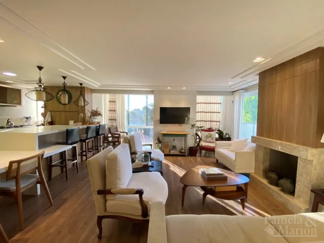Sala de estar com sofá, mesa de centro e lareira em ambiente interno.