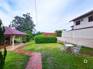 Vista externa da propriedade com jardim e caminho de tijolos.