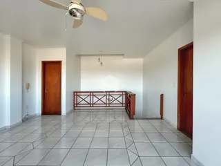 Hall de entrada com piso de cerâmica e portas de madeira.