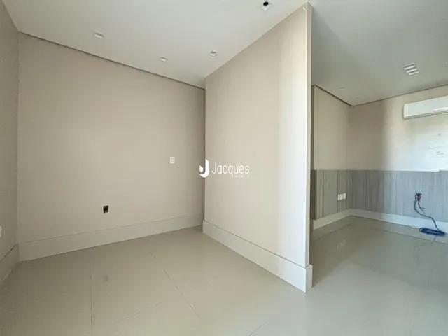 Vista interna de um ambiente com piso claro e paredes brancas.
