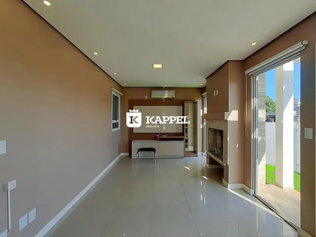 Sala de estar com piso claro e lareira em ambiente interno.