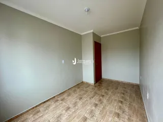Vista de um corredor interno com paredes claras e piso de cerâmica.