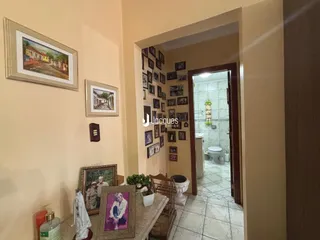 Hall de entrada com quadros nas paredes de uma residência.