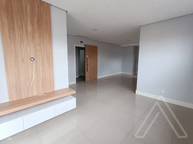 Hall de entrada com piso de porcelanato claro e painel de madeira na parede.