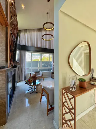 Sala de estar com piso de porcelanato claro e cortinas claras.