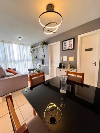 Sala de estar moderna com sofá e mesa de jantar em um apartamento.