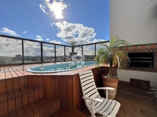 Vista de um terraço com banheira de hidromassagem e deck de madeira.