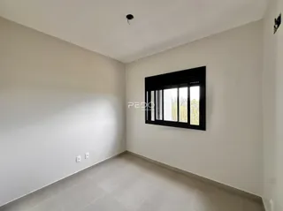Ambiente interno de uma sala com paredes brancas e piso claro.