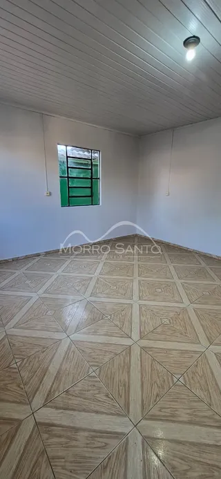 Vista interna de um ambiente com piso de ladrilhos claros e teto branco.