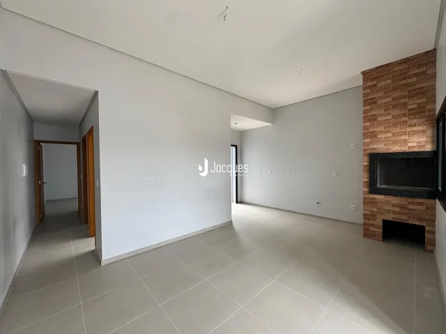 Vista de um corredor interno com parede de tijolos aparentes em um imóvel.