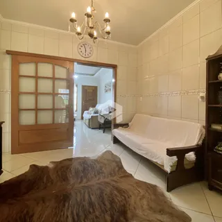 Sala de estar com sofá e porta de madeira em um imóvel no Brasil.