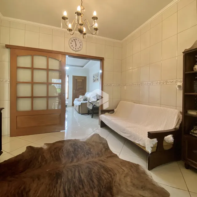 Sala de estar com sofá e porta de madeira em um imóvel no Brasil.