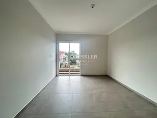 Vista interna de um ambiente com paredes brancas e piso de cerâmica.