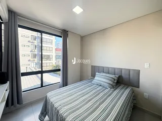 Quarto com vista para a cidade e grande janela.