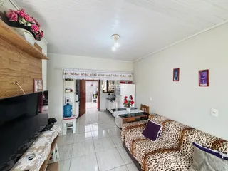 Sala de estar com sofá e piso de cerâmica em uma residência.