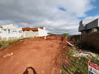 Vista externa de um terreno com construção ao fundo.