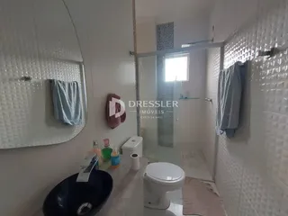 Foto de um banheiro com azulejos brancos e louças sanitárias.