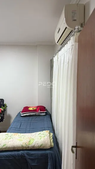 Quarto com cama e cortinas brancas.