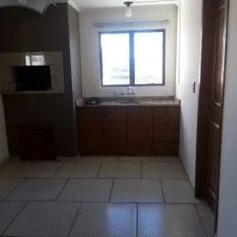 Foto interna de uma cozinha com armários de madeira e piso de cerâmica.