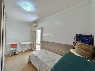 Quarto com cama e cabeceira de madeira.