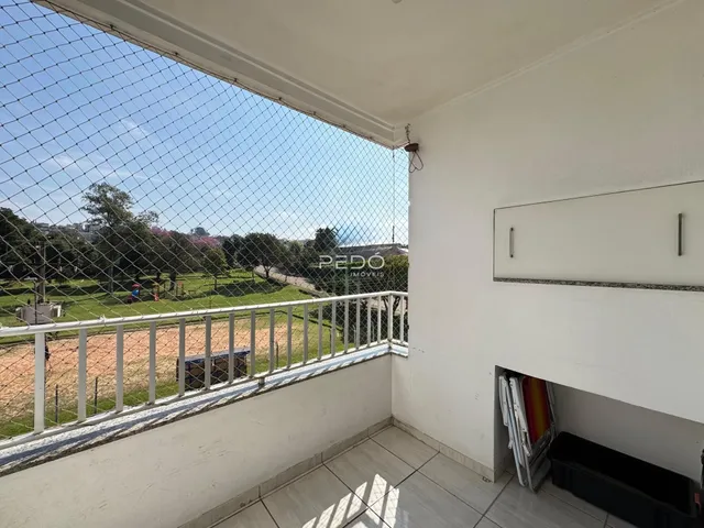 Vista da varanda com cerca de tela de arame e paisagem verde.