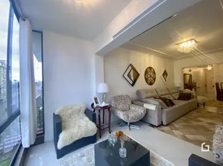 Sala de estar com grandes janelas e decoração clara.