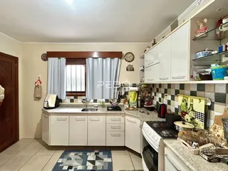 Cozinha com armários brancos e revestimento de azulejos na área de Lajeado.
