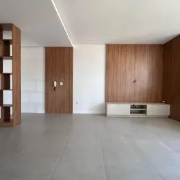 Foto de um ambiente interno com piso claro e painéis de madeira.