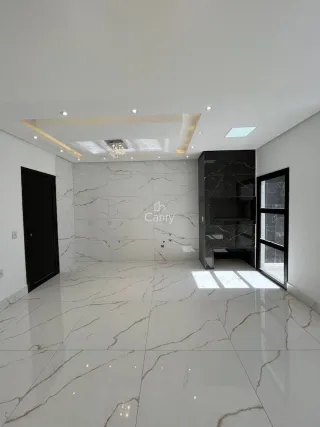 Sala ampla com piso de mármore branco e iluminação clara.