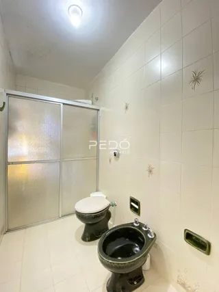 Foto de um banheiro com revestimento de azulejos brancos.