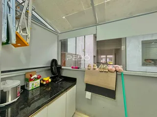 Vista da cozinha com armários e bancada em um imóvel no Brasil.