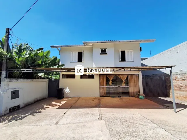 Fachada de uma residência branca com cobertura em Lajeado, Brasil.