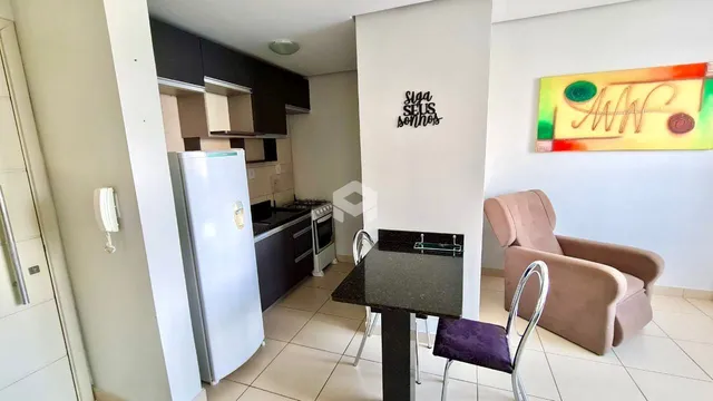 Sala de estar com cozinha e mesa de jantar em um imóvel no Brasil.