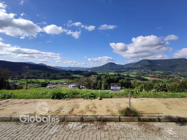 Vista panorâmica de paisagem rural com colinas verdes ao fundo.