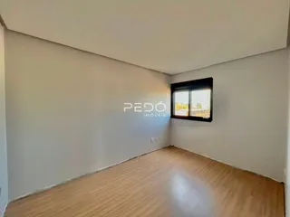 Ambiente interno de uma sala com piso de madeira e janela.