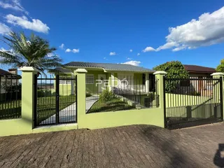 Fachada de uma casa em Lajeado, Brasil com cerca e portão verde.