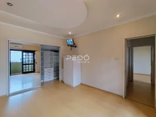 Sala de estar com piso de madeira clara e paredes brancas.