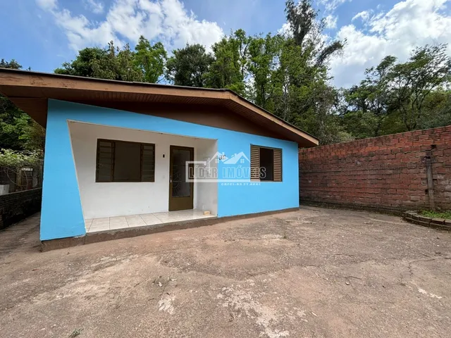 Fachada de uma residência em Lajeado, Brasil, com parede azul e detalhes em branco.