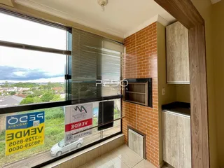 Vista da sala com parede de tijolos aparentes e grande janela.