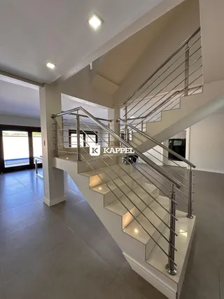 Foto de um corredor com escadaria de metal em um imóvel residencial.