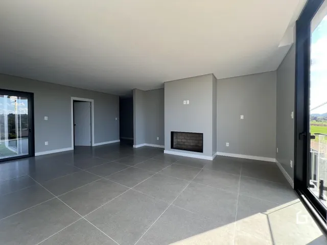 Ambiente interno moderno com piso de porcelanato cinza claro e lareira.