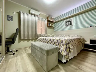 Quarto com cama e decoração de parede em Lajeado.