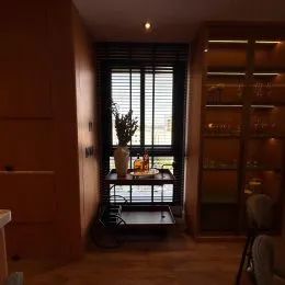Interior de um cômodo com piso de madeira e painéis escuros.