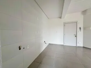 Hall de entrada com paredes brancas e piso de cerâmica.